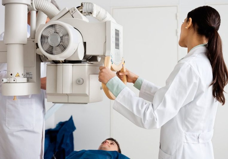 Female Radiologist Performing X-ray On Patient Female Radiologist Performing X-ray On Patient